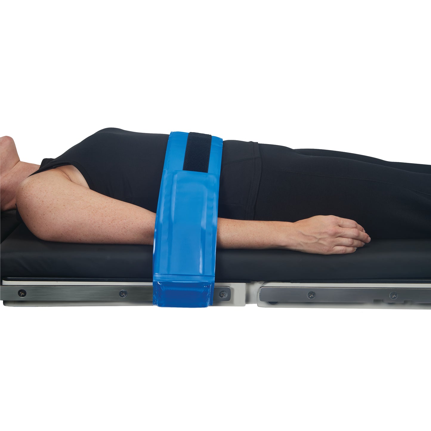 A person lies on a table with an AliMed AliBlue Gel Body Strap securing their arm, showing use for stabilization and comfort.