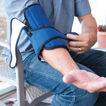 A person adjusting a Brownmed IMAK RSI Pil-O-Splint Adjustable Elbow Support, featuring a blue padded design on their left arm.