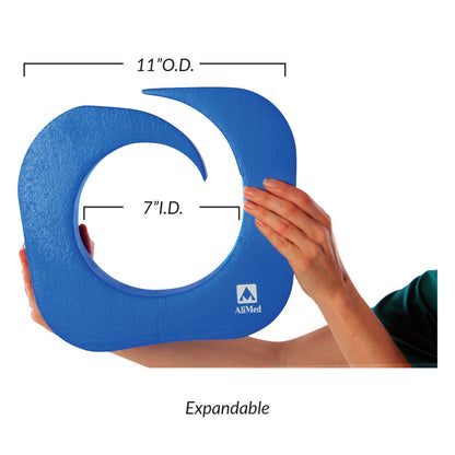 An AliMed Vinyl-Coated Operative Leg Holder in blue, shaped like a swirl, measuring 11" O.D. and 7" I.D. It is labeled "Expa.