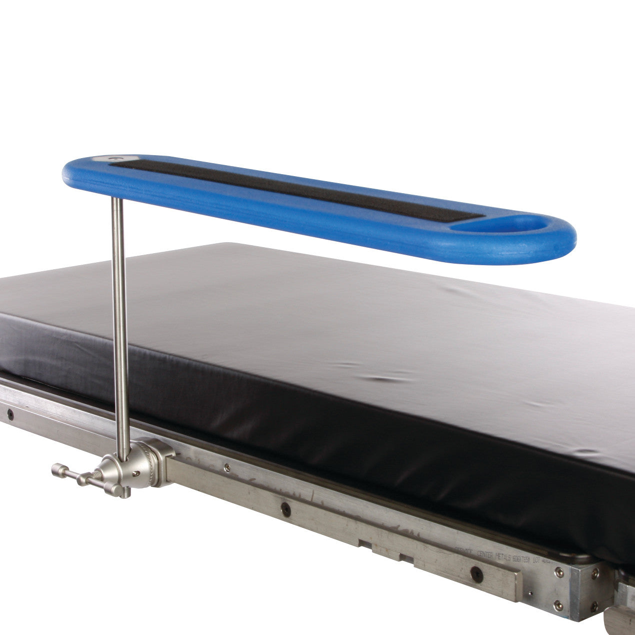 An AliMed Radiolucent Armboard attached to a medical table with a metal bracket and covered in a black pad.