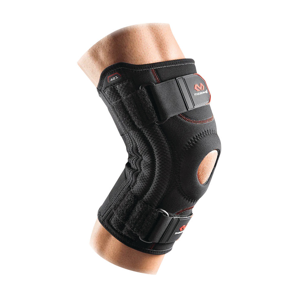 A knee wearing a McDavid Patella Knee Support with open patella design, adjustable straps, and reinforced stitching for support.