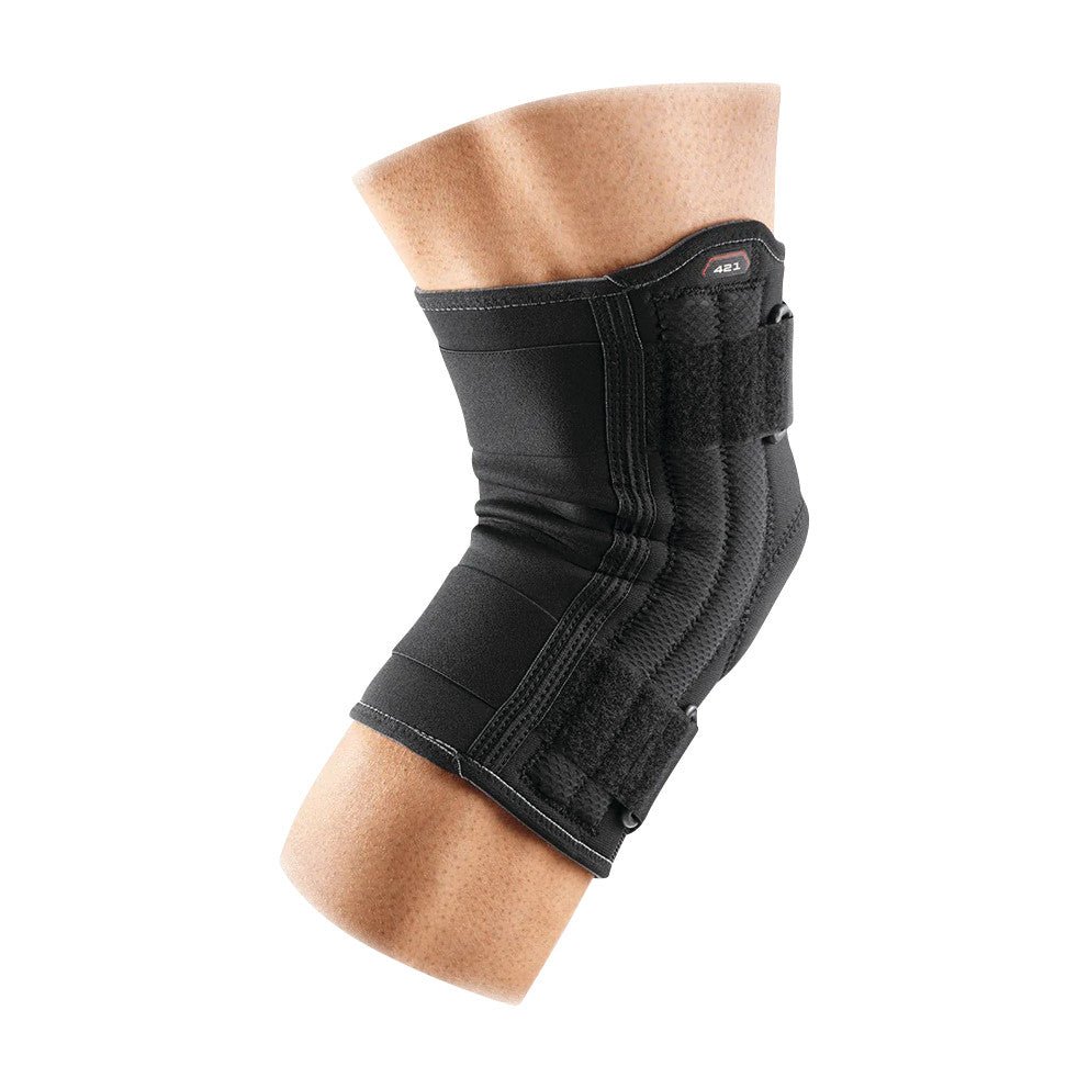 A torso wearing a McDavid Patella Knee Support, a black padded brace with adjustable straps, wrapped around the knee area.
