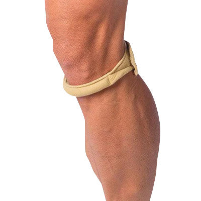 A person wearing a beige Cho-Pat Knee Strap below the knee, providing support and compression around the patellar tendon area.
