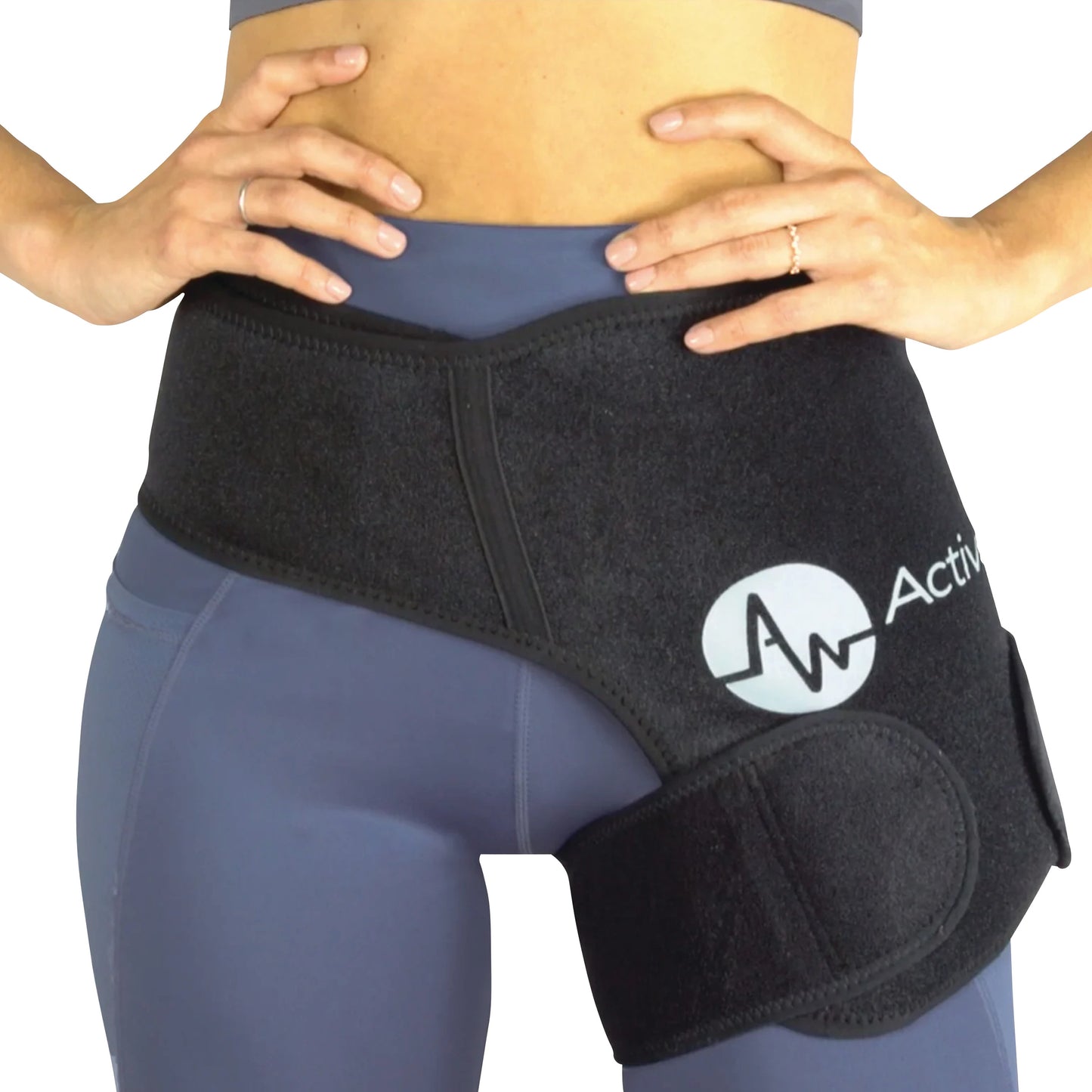 A person wears the ActiveWrap black hip support wrap over blue leggings, with hands resting on the waist.