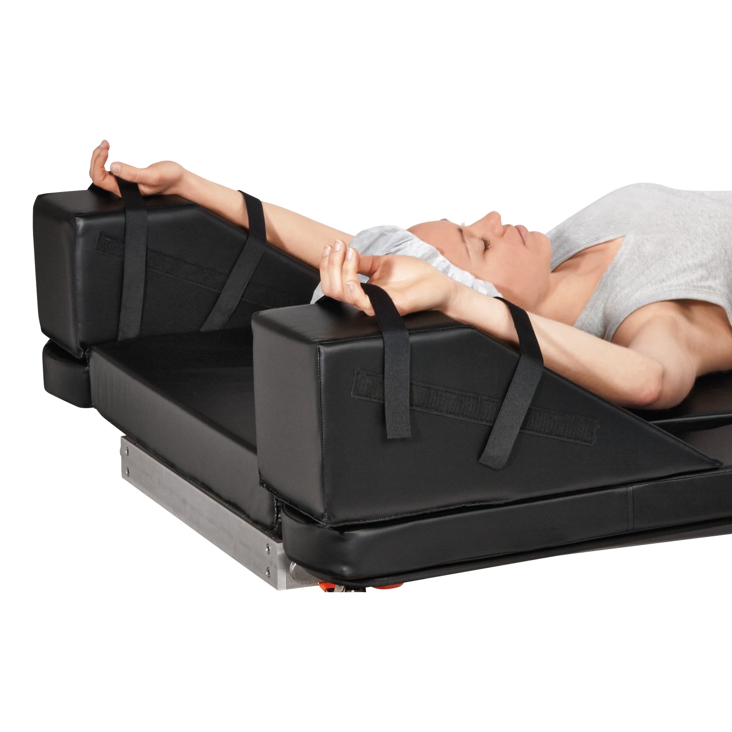 A person lies back with arms outstretched on the AliMed Upper Extremities Clearview Wedge Set. Straps secure the arms in place.