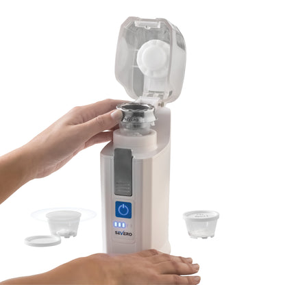 A person's hand operates the Severo Electric Pill Grinder with a lid open. A crushed pill container and lid are placed nearby.