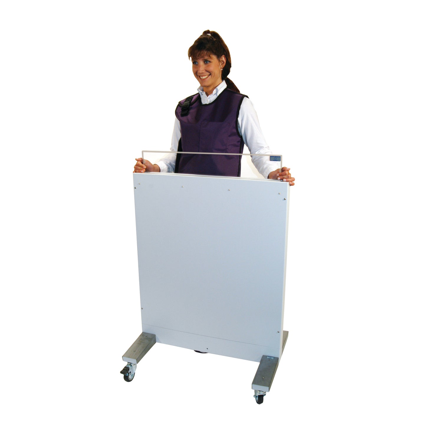 A person stands behind a RayShield Adjust-A-Height Barrier, wearing a protective vest. The barrier is on wheels for easy mobility.
