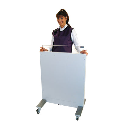 A person stands behind a RayShield Adjust-A-Height Barrier, wearing a protective vest. The barrier is on wheels for easy mobility.