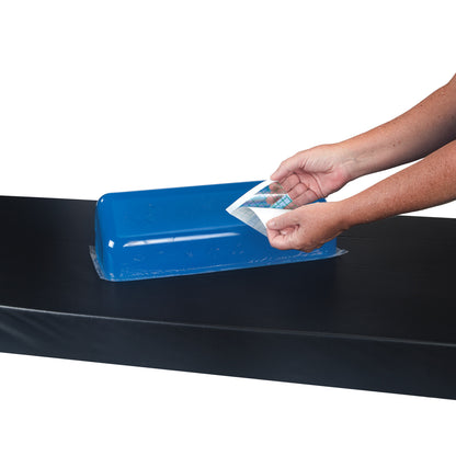Hands use the AliMed Gel Repair Kit to apply a clear adhesive sheet on a blue gel pad, placed on a black surface.