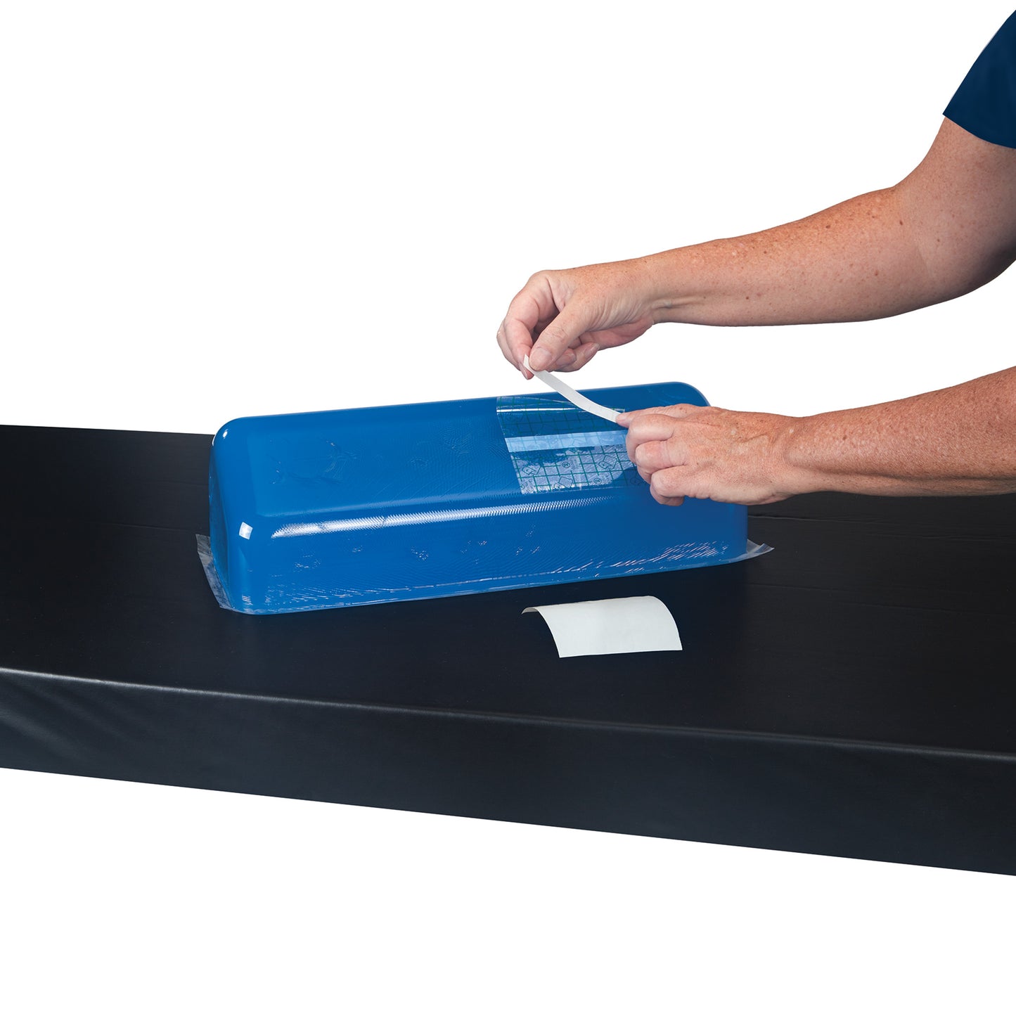 Person applies a patch using the AliMed Gel Repair Kit on a blue gel pad placed on a black surface.