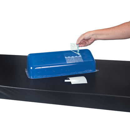 A hand applies a patch to a blue cushion using the AliMed Gel Repair Kit. The cushion rests on a black surface.