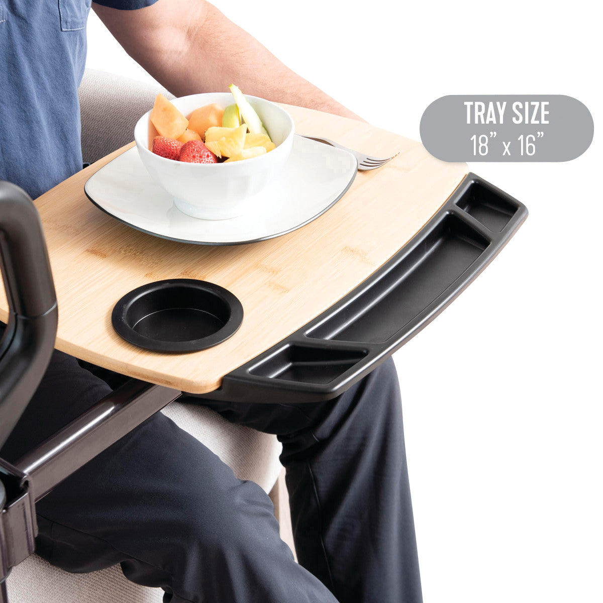 An Assist-A-Tray with a bamboo surface. It holds a bowl of fruit, a fork, and has a built-in cup holder. Tray size: 18"x16".