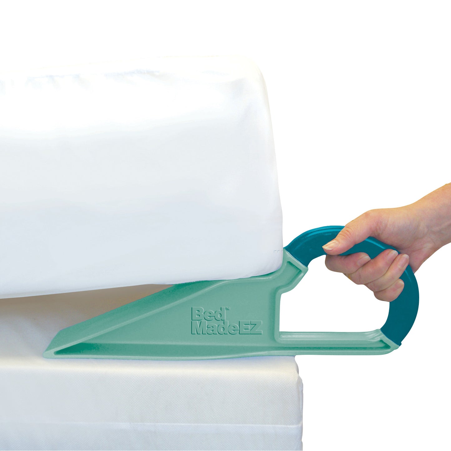 A hand uses the Bed MadeEZ Mattress Lifter to lift a mattress. The device is turquoise and wedge-shaped with a handle.