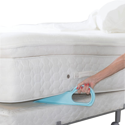 A person uses a Bed MadeEZ Mattress Lifter tool to lift a white mattress, showing its ergonomic design for easier handling.