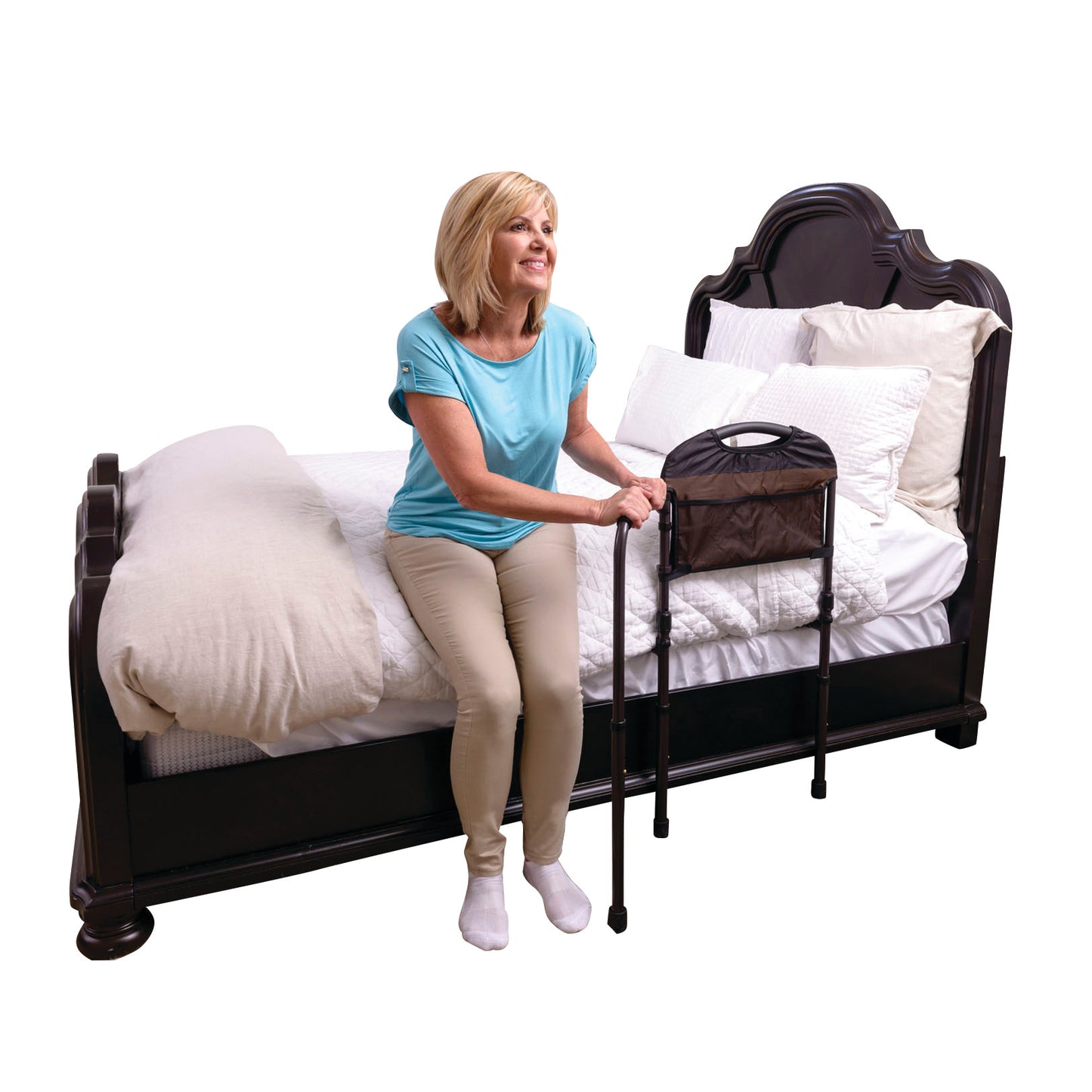 A person uses the Stander Mobility Bed Rail to assist in getting out of bed. The rail is attached to the side of a bed.