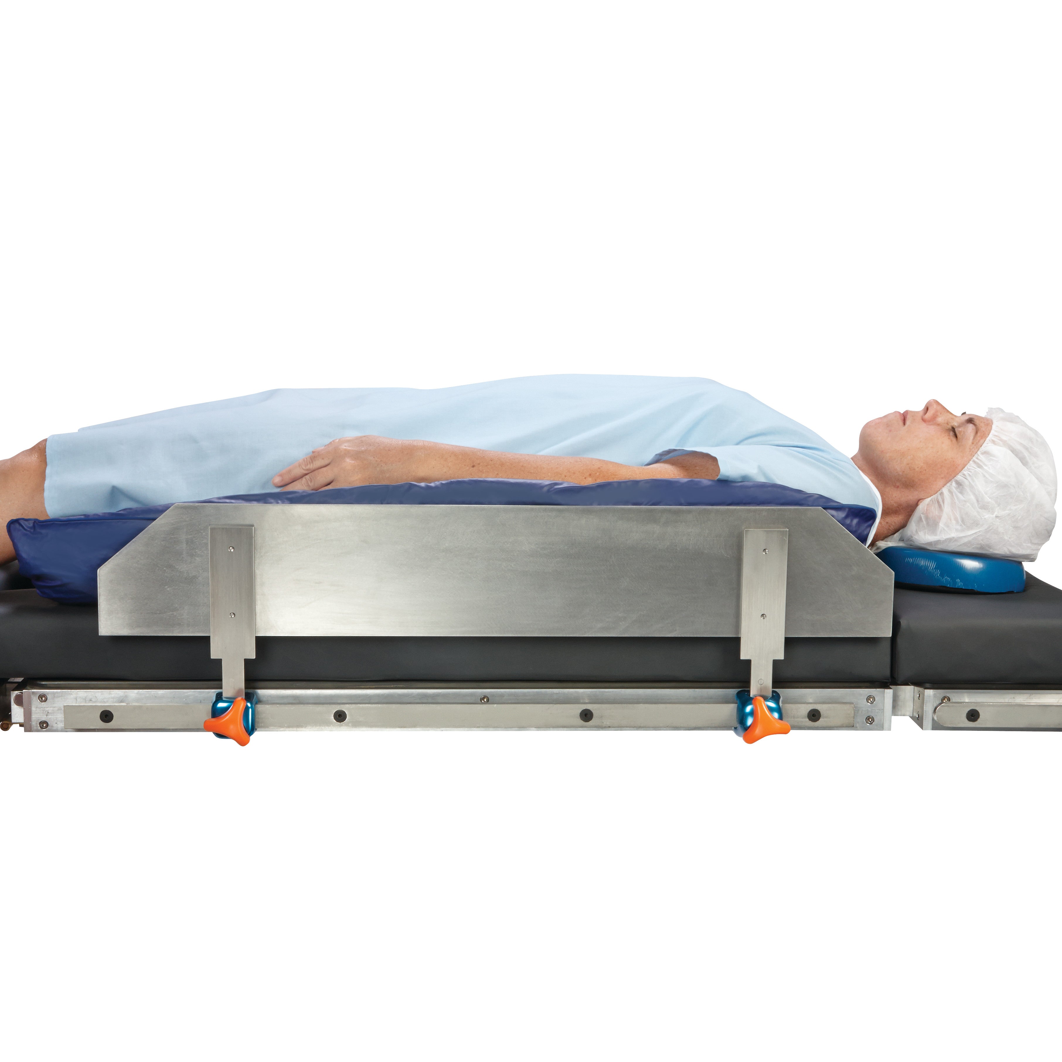 Person lying on a medical table with a metal rail. Product: AliMed Lateral Fence, used for patient positioning and support.