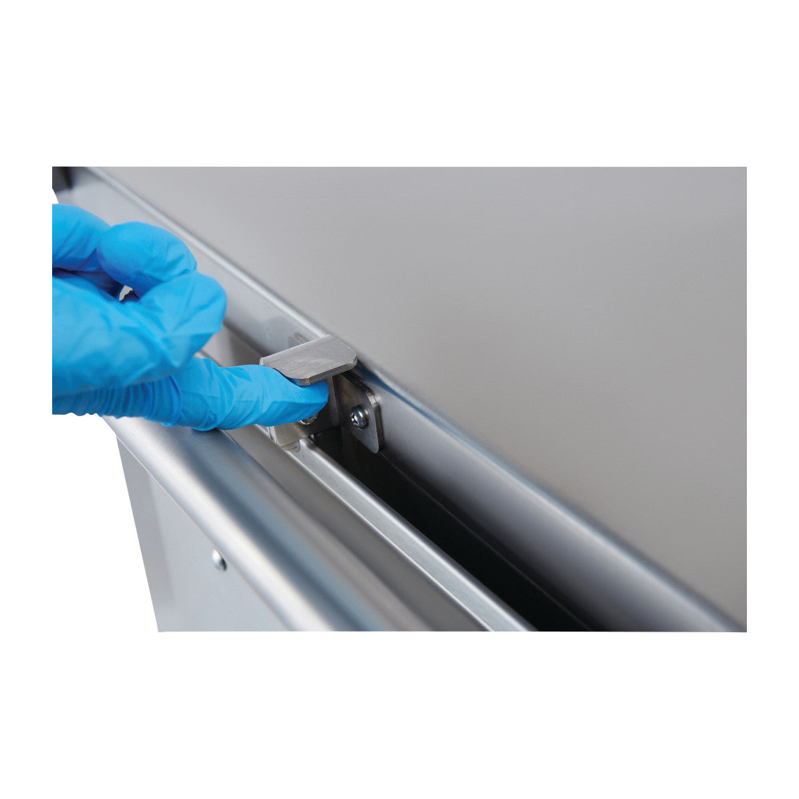 A hand wearing a blue glove operates the latch of a Blickman Multipurpose Case Cart. The cart is metallic with a smooth surface.