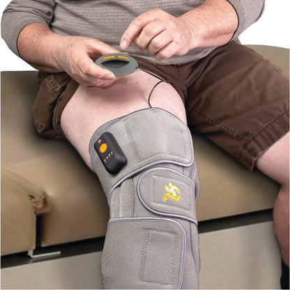 A person uses the Pain Management Technologies JStim 1000 Knee System, a knee wrap with a control device on a knee.
