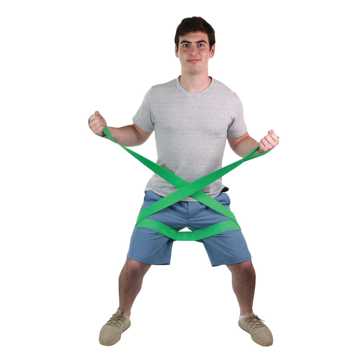 A person demonstrates stretching a green CanDo Multi-Grip Exerciser, showing its flexibility and grip-holding capability.