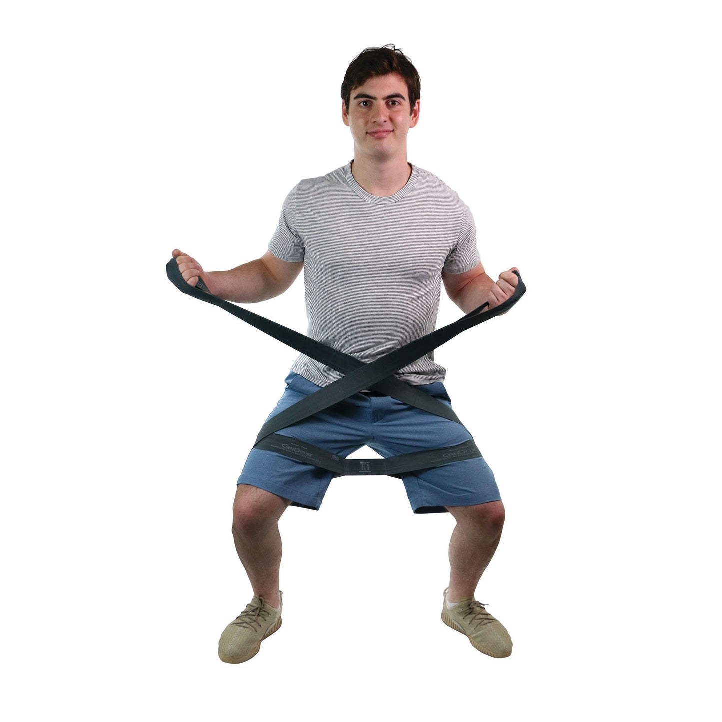 A person uses the CanDo Multi-Grip Exerciser, performing a squat. The strap is wrapped around their arms and legs.