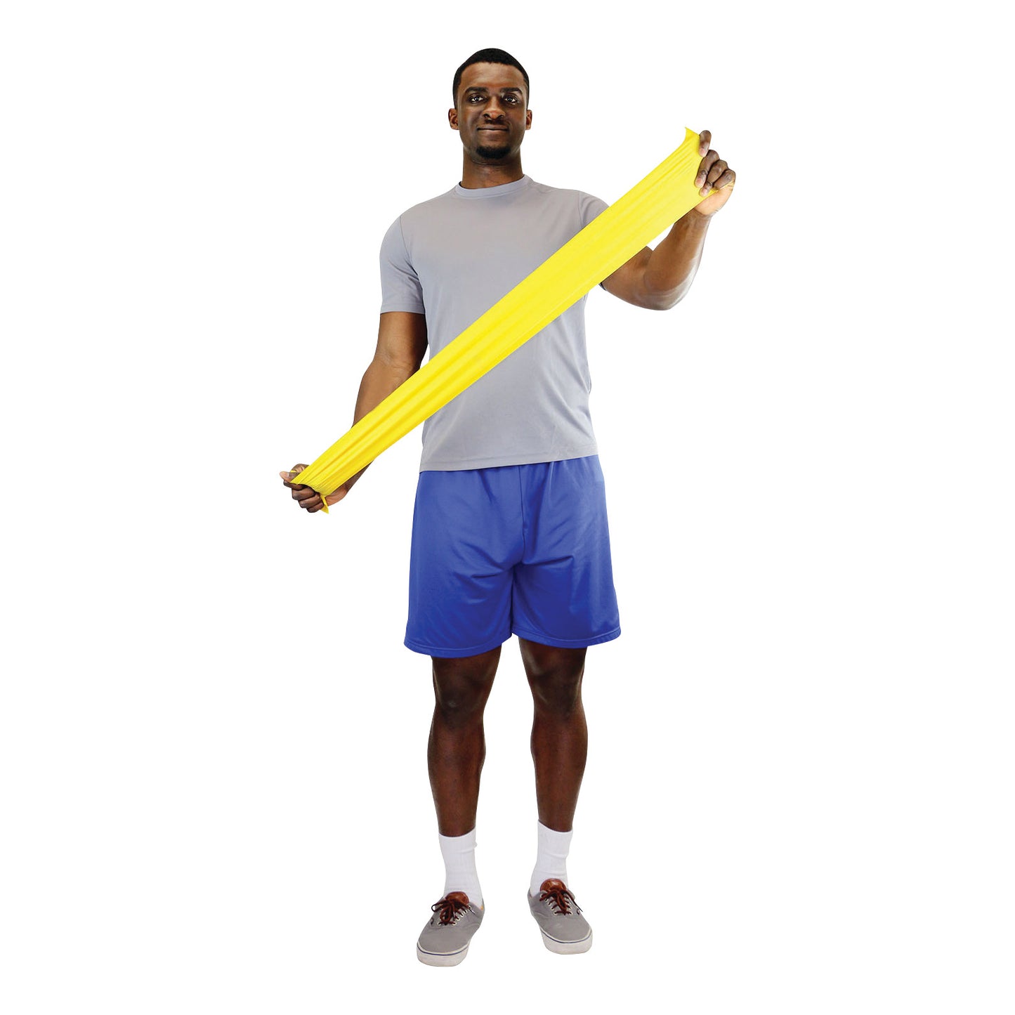 A man stretches a yellow CanDo Non-Latex Exercise Band while standing, wearing a gray shirt and blue shorts.