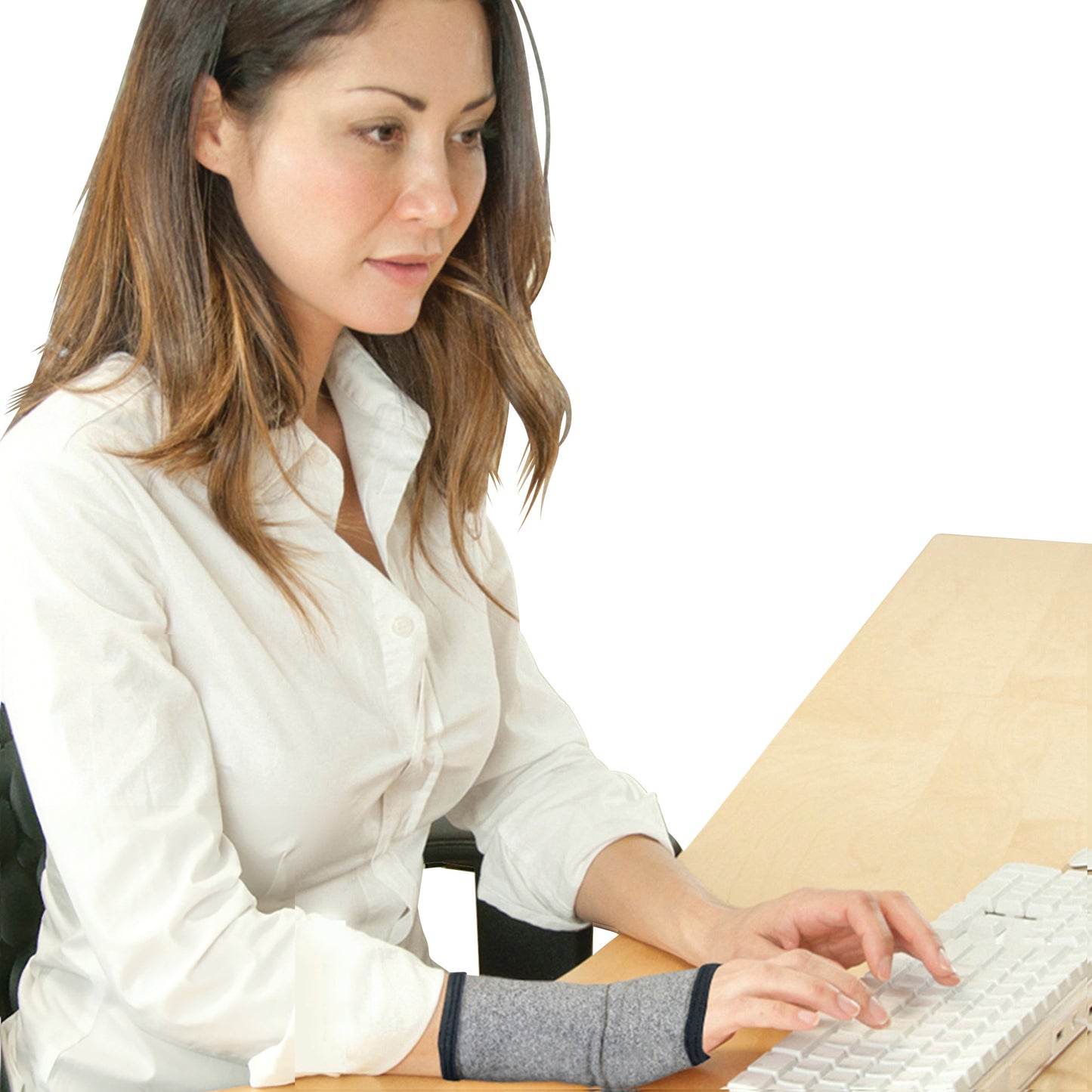 A person types on a keyboard wearing a Brownmed IMAK Compression Arthritis Wrist Sleeve on their wrist.