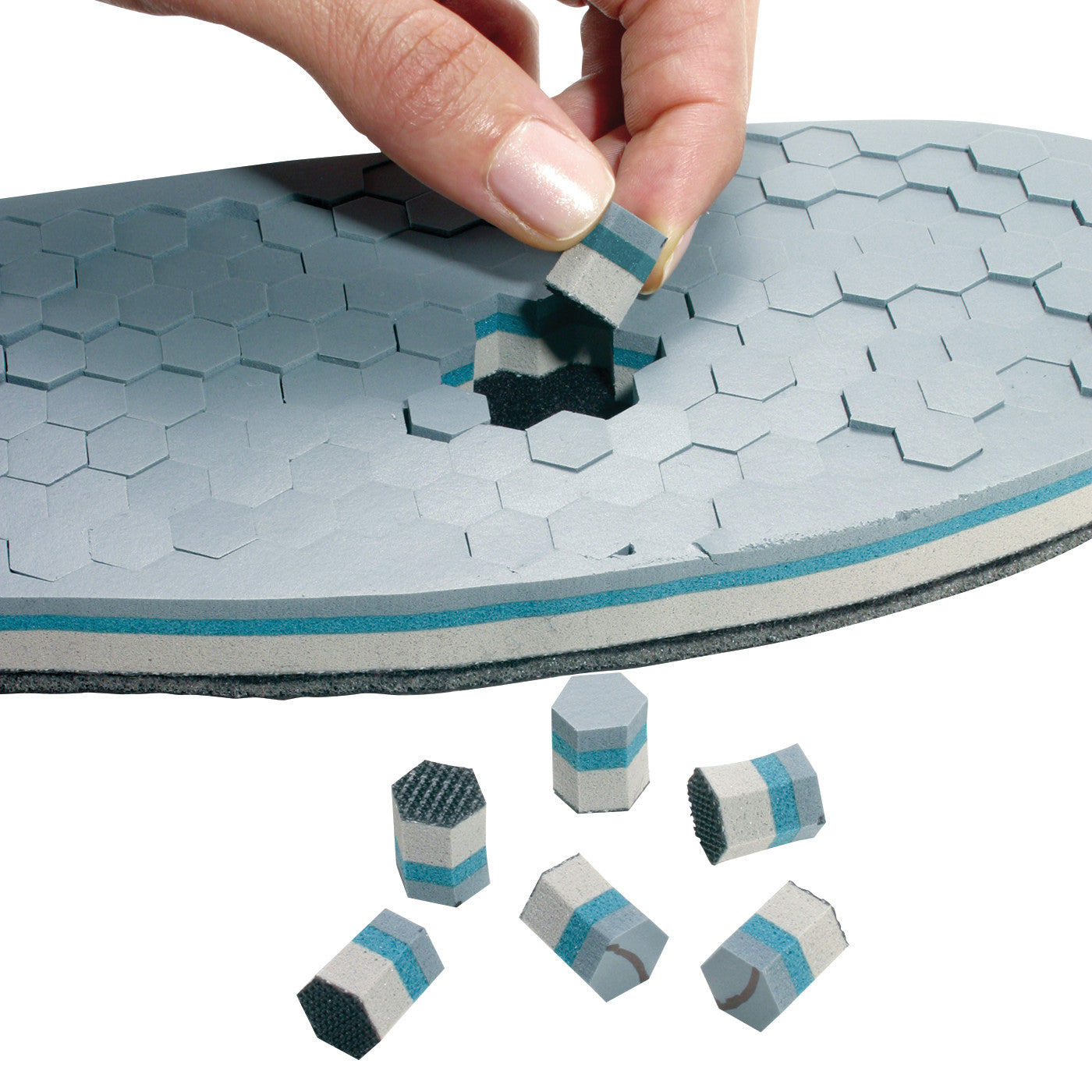 The SSUR DH Offloading Walker insole has removable hexagonal pieces for customizable support. A hand removes a multi-layer piece.