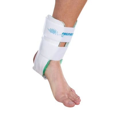 A person's foot wearing an Aircast Air-Stirrup Ankle Brace, with white straps securing the ankle for support and stability.