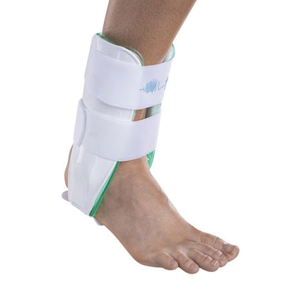A person's foot and ankle wearing an Aircast Air-Stirrup Ankle Brace, featuring a white and green design, secured with straps.