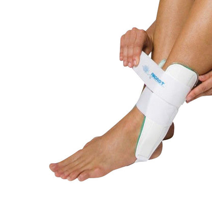 A person adjusts the Aircast Air-Stirrup Ankle Brace on their left foot, featuring a white strap and supportive rigid sides.