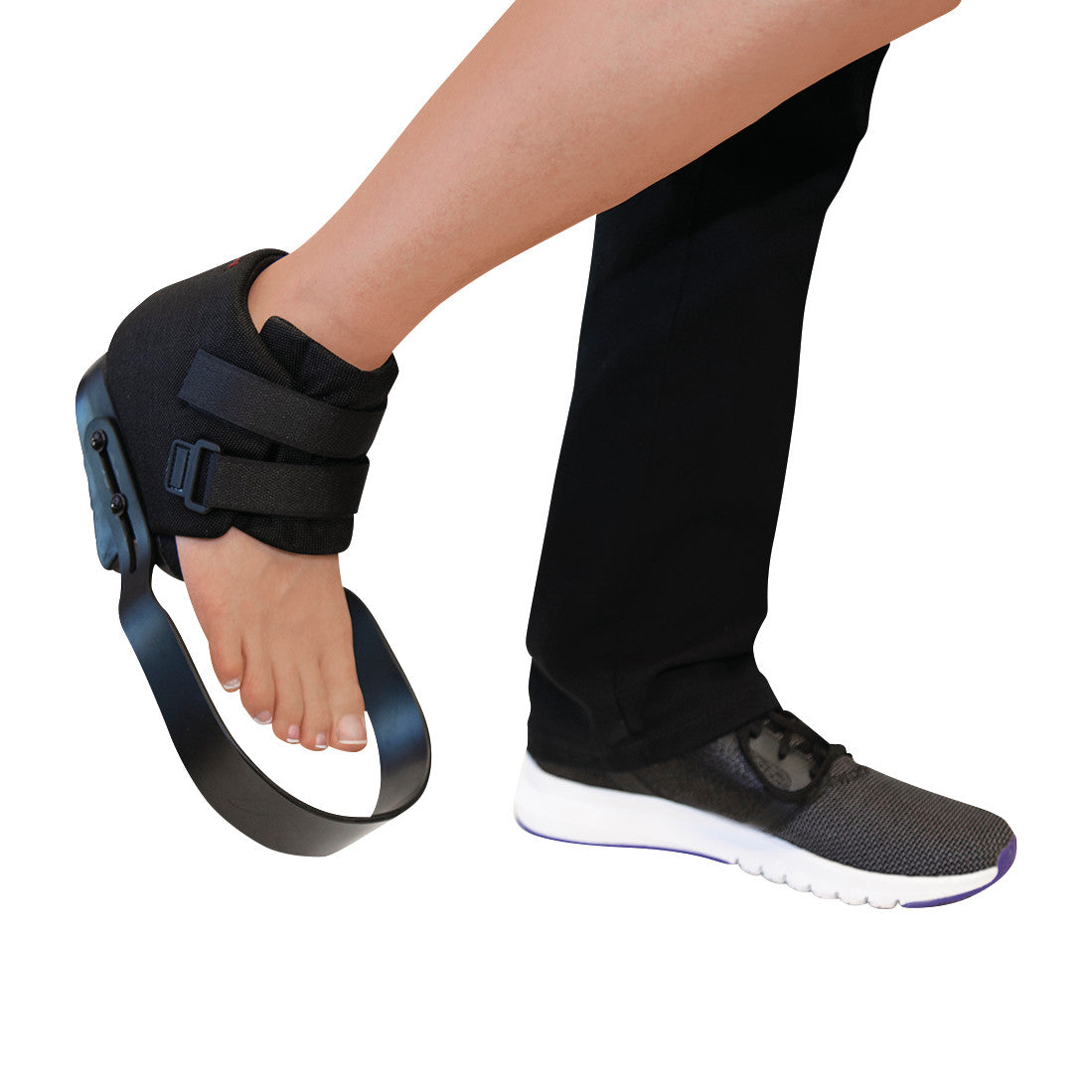 Person wearing a  GloboPed Forefoot Relief Orthosis, with black straps, lifting the forefoot off the ground next to a sneaker.