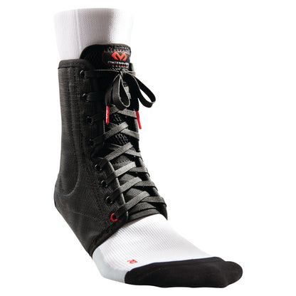 The McDavid Lightweight Laced Ankle Brace in black is shown on a mannequin foot wearing a white sock with black toe and heel.