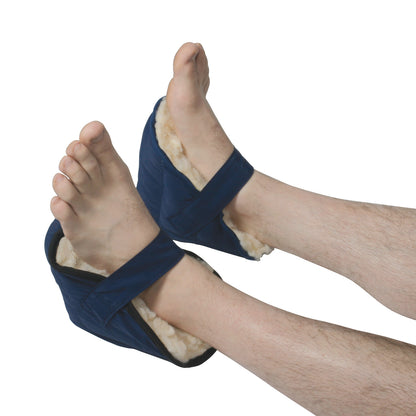 Two feet are wrapped in AliMed Fleece Heel Cups with blue fabric and soft fleece lining, secured with adjustable straps.