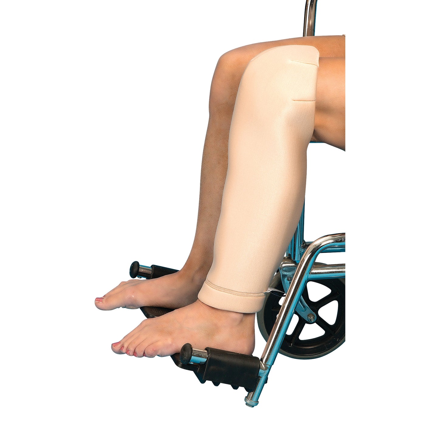 A person in a wheelchair wears a DermaSaver Shin-Knee Tube on their left leg, with the foot resting on a footrest.