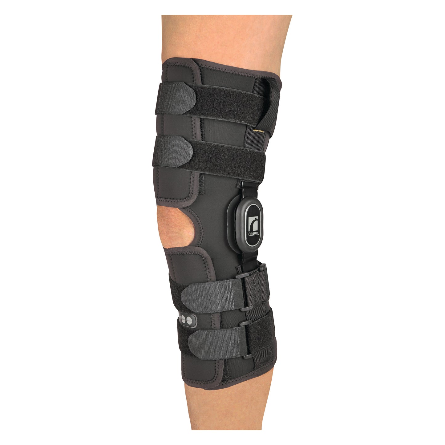 A person wears an �ssur Rebound ROM Knee Brace with Long Wrap, featuring multiple adjustable straps and a hinge for knee support.