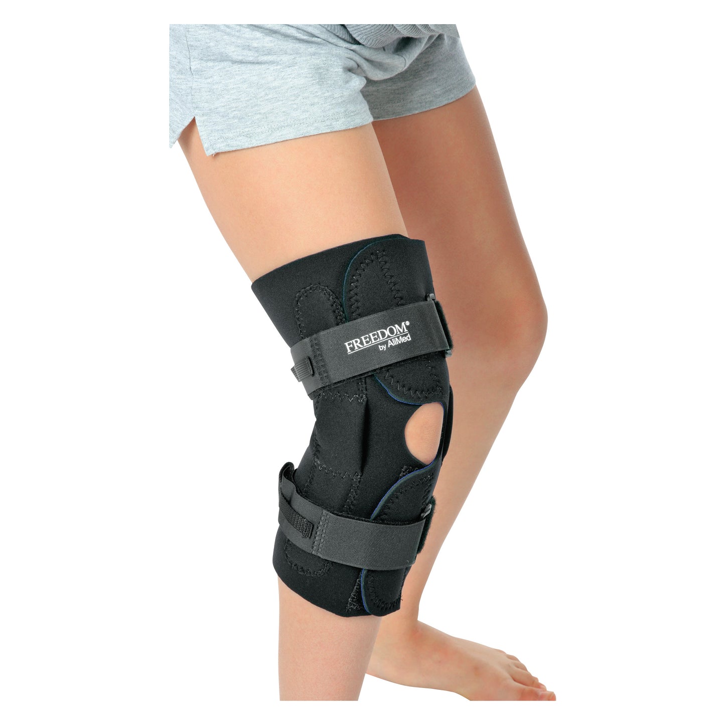 Person wearing an AliMed FREEDOM Pediatric Wraparound Knee Brace with exposed areas and adjustable straps, over bare skin.