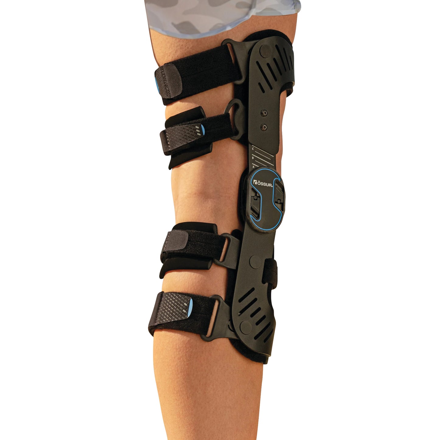 A leg wearing an Ossur Rebound DUAL Knee Brace, featuring adjustable black straps and a durable hinge system for support.