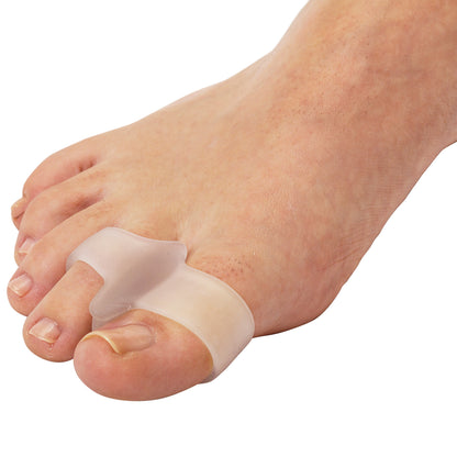 A foot wearing a PediFix Visco-GEL ToeBuddy, a soft gel separator placed between the big toe and second toe for alignment.