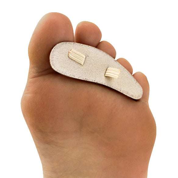 A foot with a Silipos Hammer Toe Crest applied, showing a padded support with securing straps on the underside of the toes.