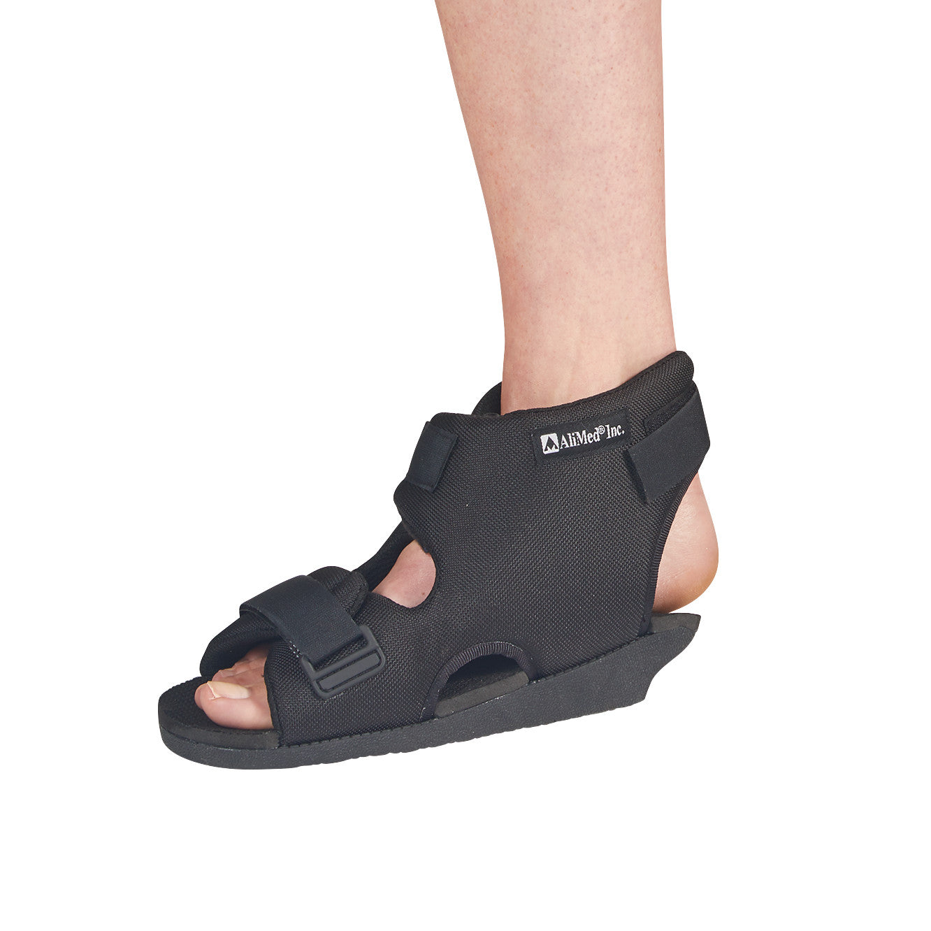 A leg wearing an AliMed Open Heel Orthosis in black, featuring adjustable straps and an open-toe design.