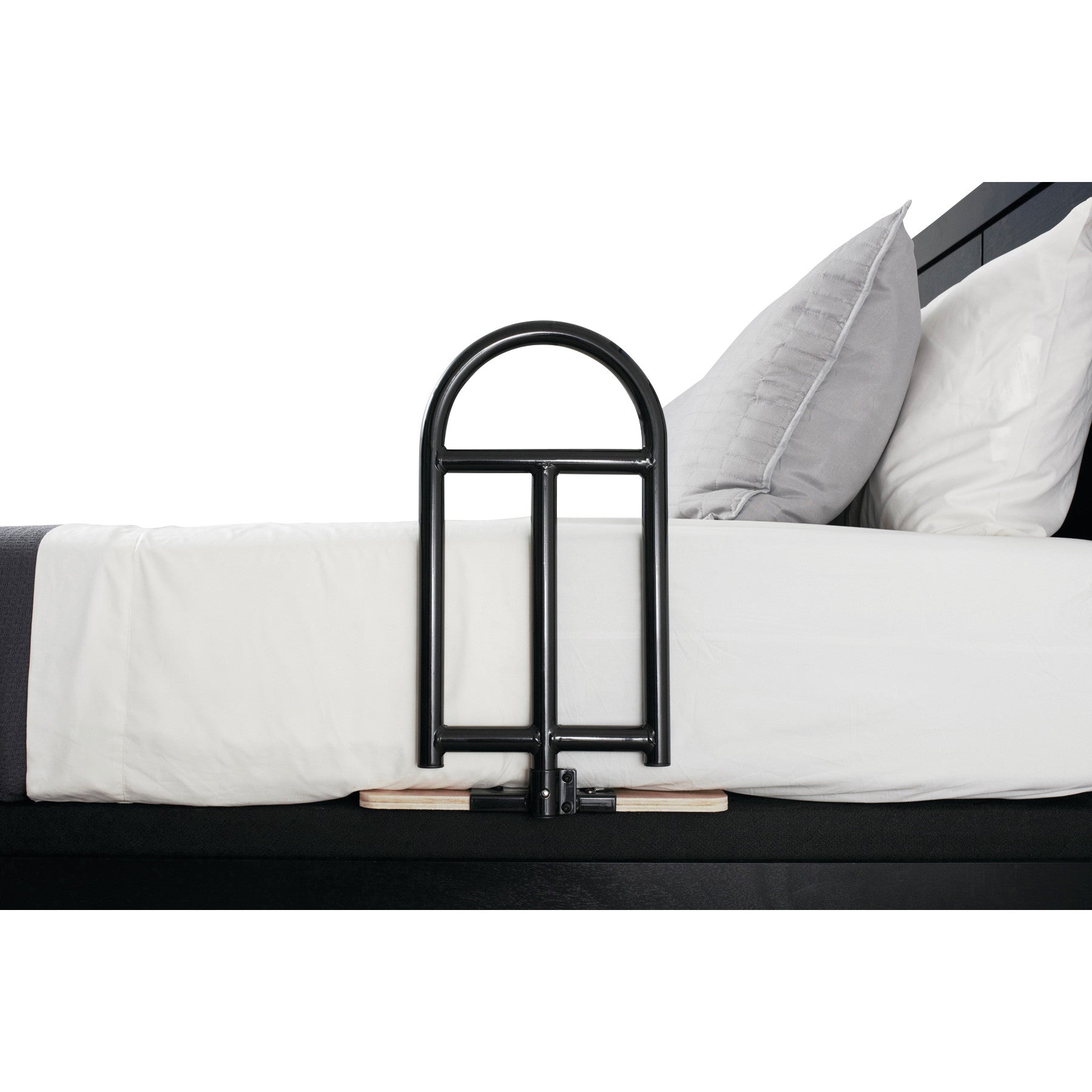 A Stander BedCane attached to the side of a bed with white sheets and gray pillows, providing support for a person getting in and out.
