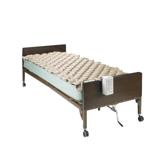 Hospital bed with Drive Medical Med-Aire Alternating Pressure Pad System. It features a textured beige pad and a control unit.
