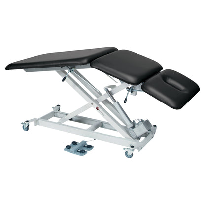 The Armedica AM-SX3000 Treatment Table is an adjustable, black-cushioned medical table with a metal frame and caster wheels.