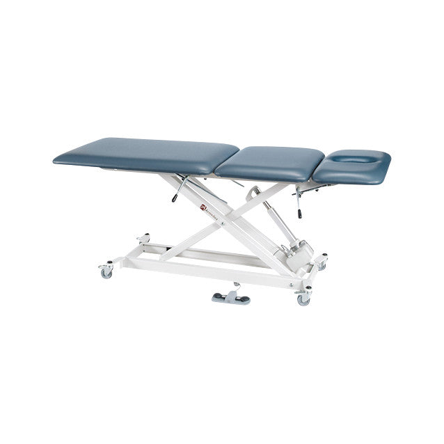 Armedica AM-SX3500 Treatment Table with adjustable sections, upholstered in blue, mounted on a white metal frame with wheels.