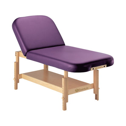 EarthLite Sedona Tilt Stationary Massage Table with a purple cushion, wooden frame, adjustable headrest, and a storage shelf.