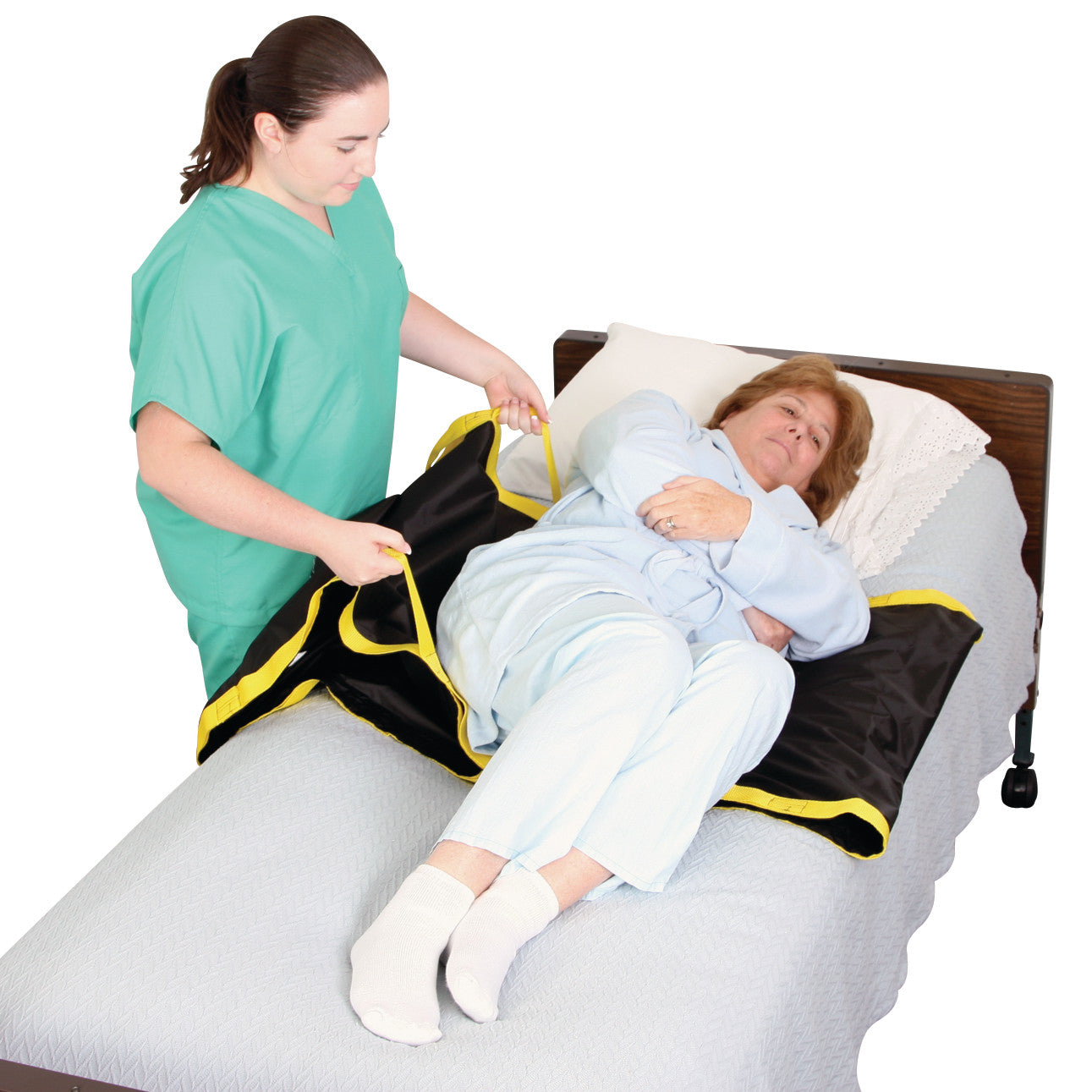 A caregiver assists a patient on a bed using the AliMed No-Lift TURNER, aiding in turning and repositioning safely.