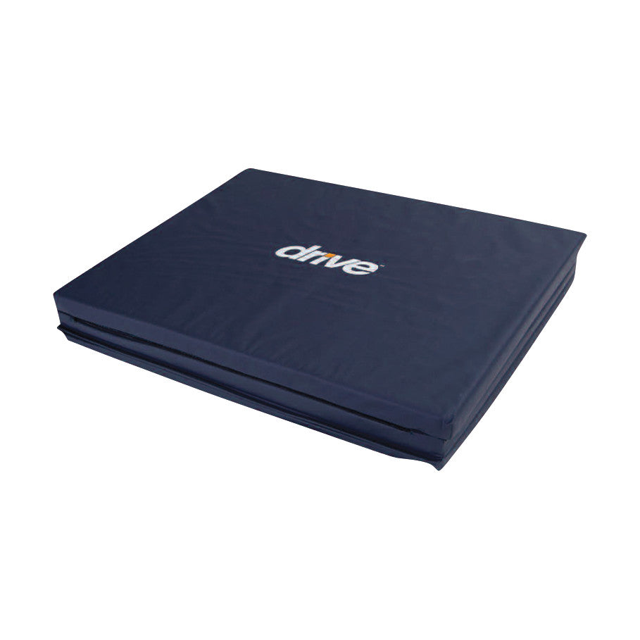 Drive Medical Tri-Fold Bedside Fall Mat in dark blue, shown folded for easy storage and use beside a bed for fall protection.