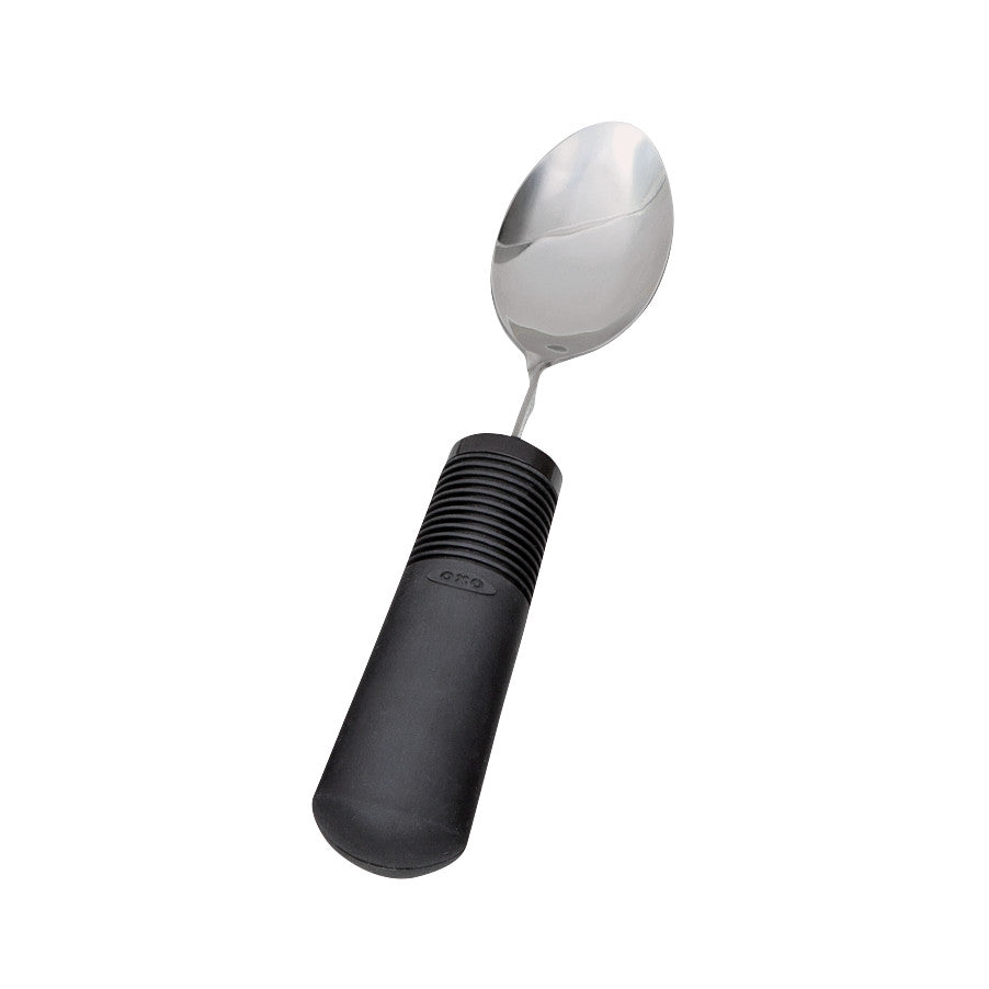 A Good Grips Standard Utensils spoon with a stainless steel head and a thick, black, non-slip handle featuring grip ridges.