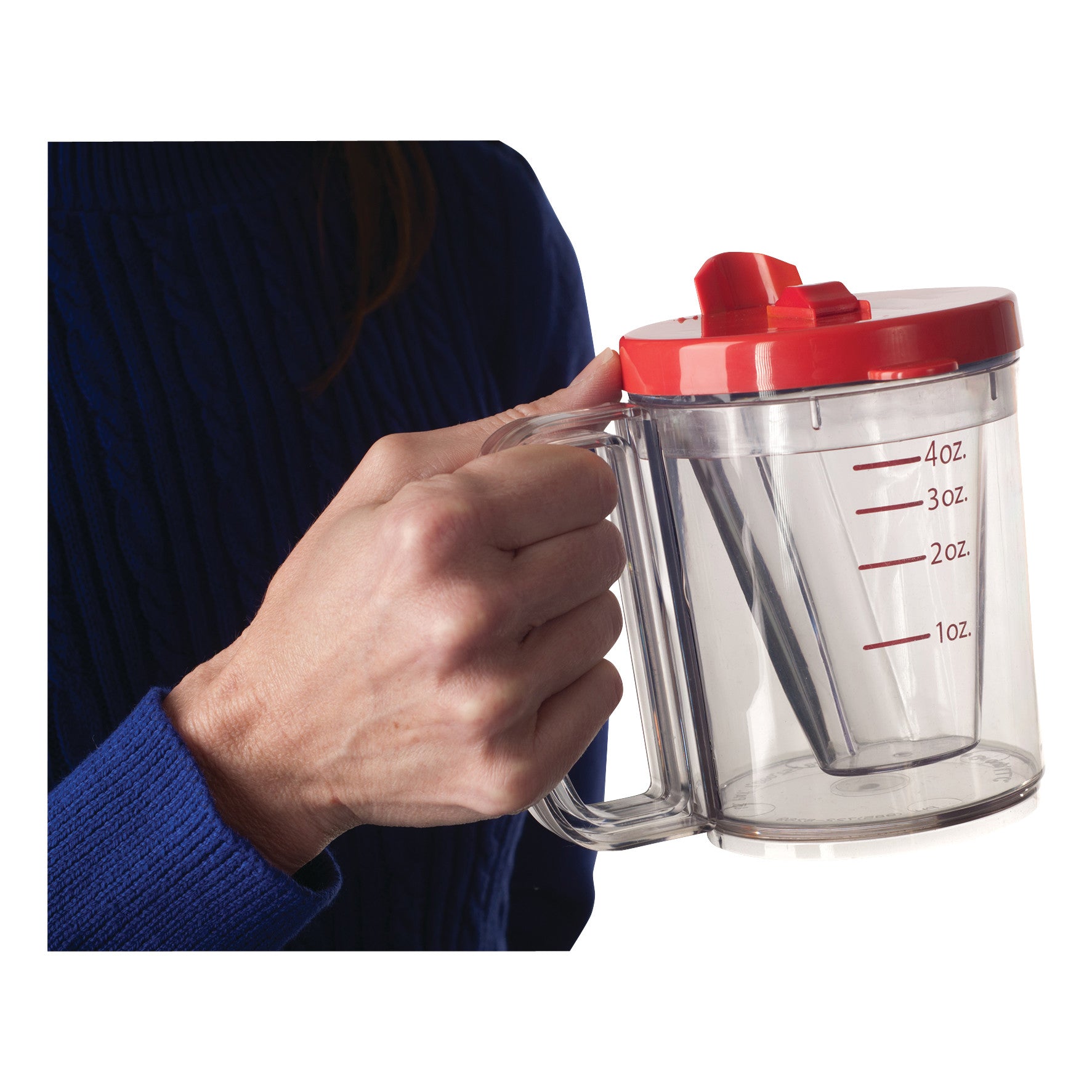 A hand holding a Wedge Cup, a clear measuring cup with a red lid and handle, marked with measurements from 1oz to 4oz.
