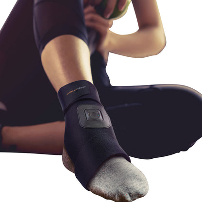A person wears an Intellinetix Foot/Ankle Therapy Wrap, a black wrap providing support, with a visible button on the side.